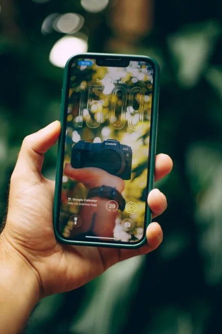 Un espace de travail moderne avec un smartphone affichant un écran et une configuration informatique, idéal pour les thèmes liés aux affaires et à la technologie.